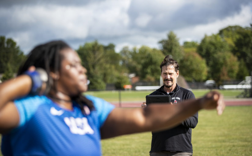 image shows Coach Larry Judge evaluates shotputter