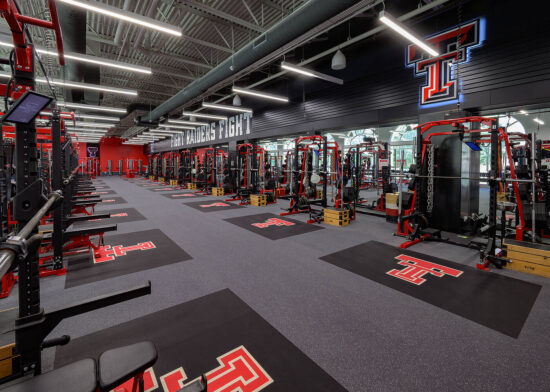 A view inside the Texas Tech University Sports Performance center with weight racks and benches.