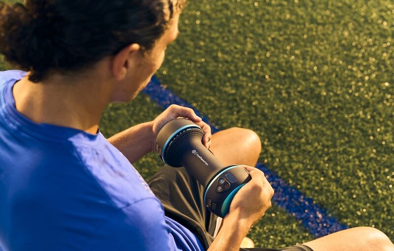 image shows an athlete sitting with the palm-cooling device held between their hands